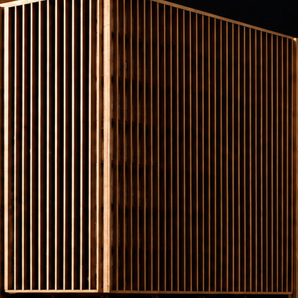 Celosías de madera. Lamas verticales cortadas con precisión que forman una piel distinta según la luz.