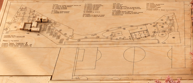 Plano grabado en madera. El plano de conjunto y la cancha se graban en el triplay de la base, con notas y trazas a escala.