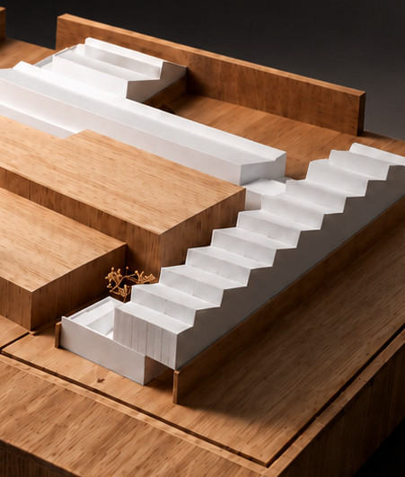 Maqueta de un conjunto de talleres sobre una gruesa base de madera, con escalinatas blancas, vehículos y hileras de árboles secos, sobre fondo oscuro.